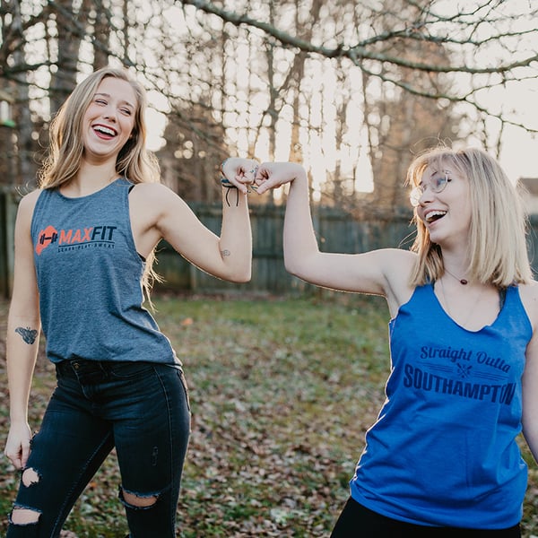 Two tank-wearing women giving fist bumps